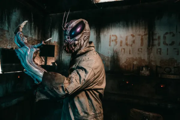 Scary alien monster character in a dark haunted house attraction.