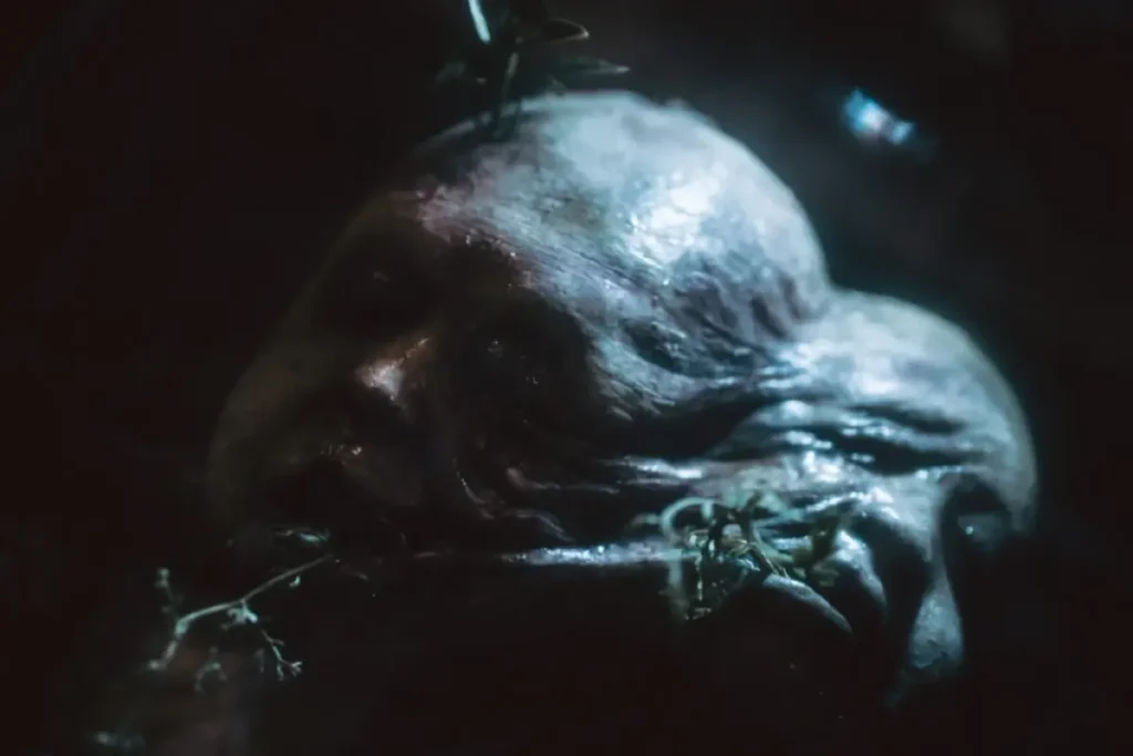 Close-up of a grotesque pale creature prop with twisted features inside Nightmare Cleveland haunted attraction
